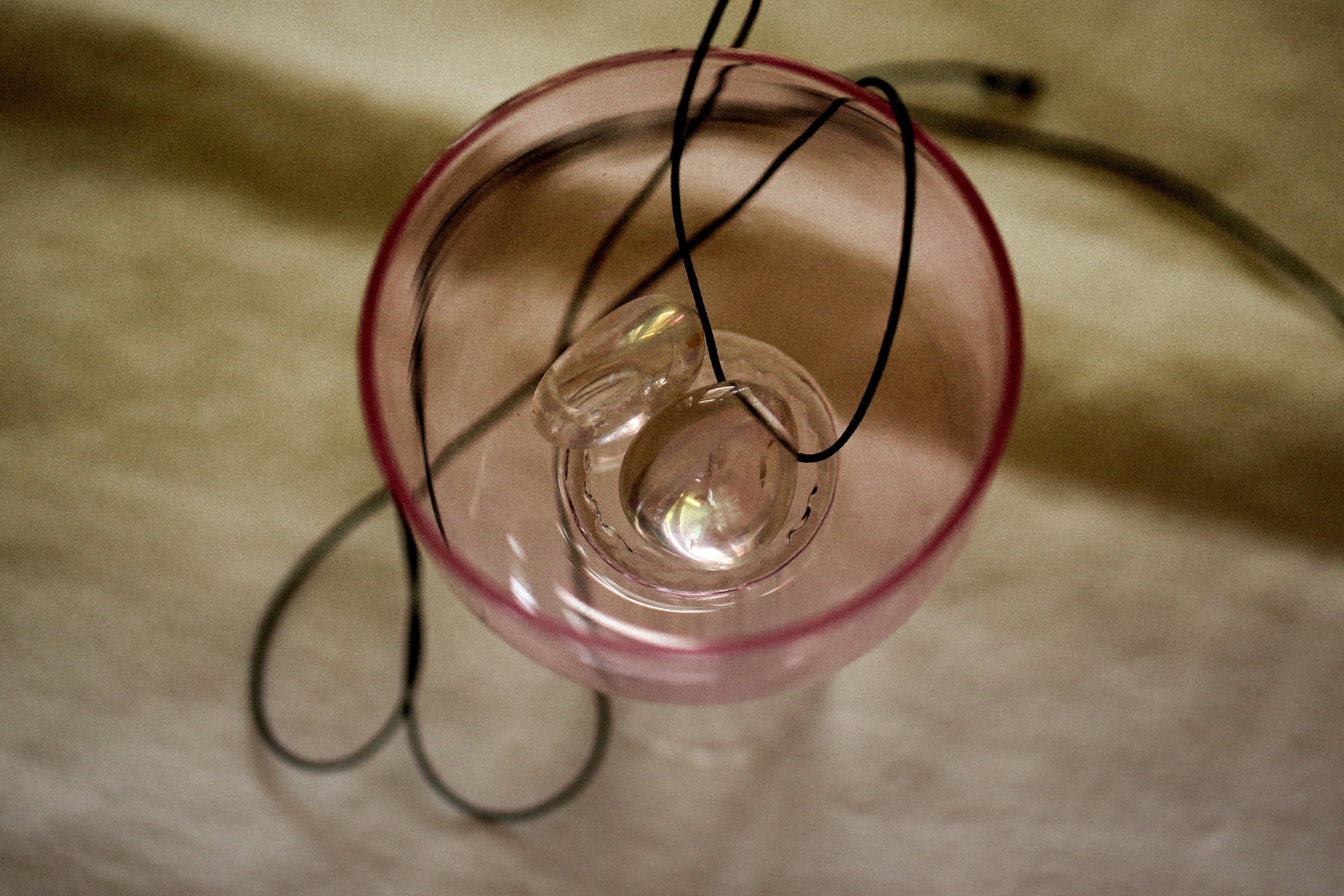 angel aura quartz stone necklace with an black cord still life image
