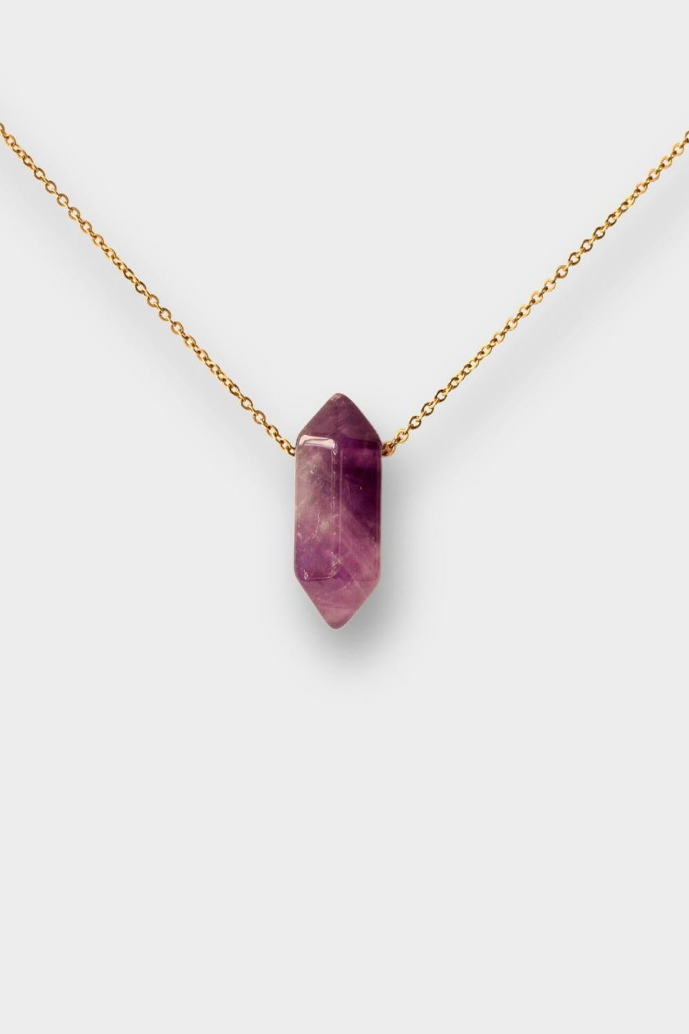 Natural Amethyst crystal necklace. The necklace features a pointed amethyst crystal pendant attached to a gold chain, creating a stunning and eye-catching piece of jewelry.