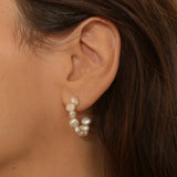 beaded pearl hoop earrings in 18k gold plated silver. The earrings feature a classic hoop design adorned with delicate beads and lustrous pearls. The gold plated silver adds a touch of elegance and sophistication to the design. The pearls are beautifully strung along the hoops, adding a timeless and glamorous element.