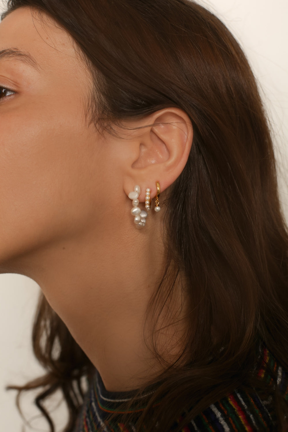 Beaded pearl hoop earrings in 18k gold plated silver. The earrings feature a classic hoop design adorned with delicate beads and lustrous pearls. The gold plated silver adds a touch of elegance and sophistication to the design. The pearls are beautifully strung along the hoops, adding a timeless and glamorous element.