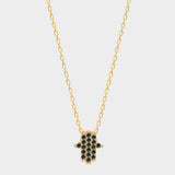a black Hamsa hand charm necklace in 18k gold plated silver. The necklace features a delicate chain with a beautifully designed Hamsa hand charm pendant. The Hamsa hand symbol is believed to bring protection, good luck, and ward off evil. The necklace is designed to be worn comfortably and can be adjusted to fit different neck sizes.