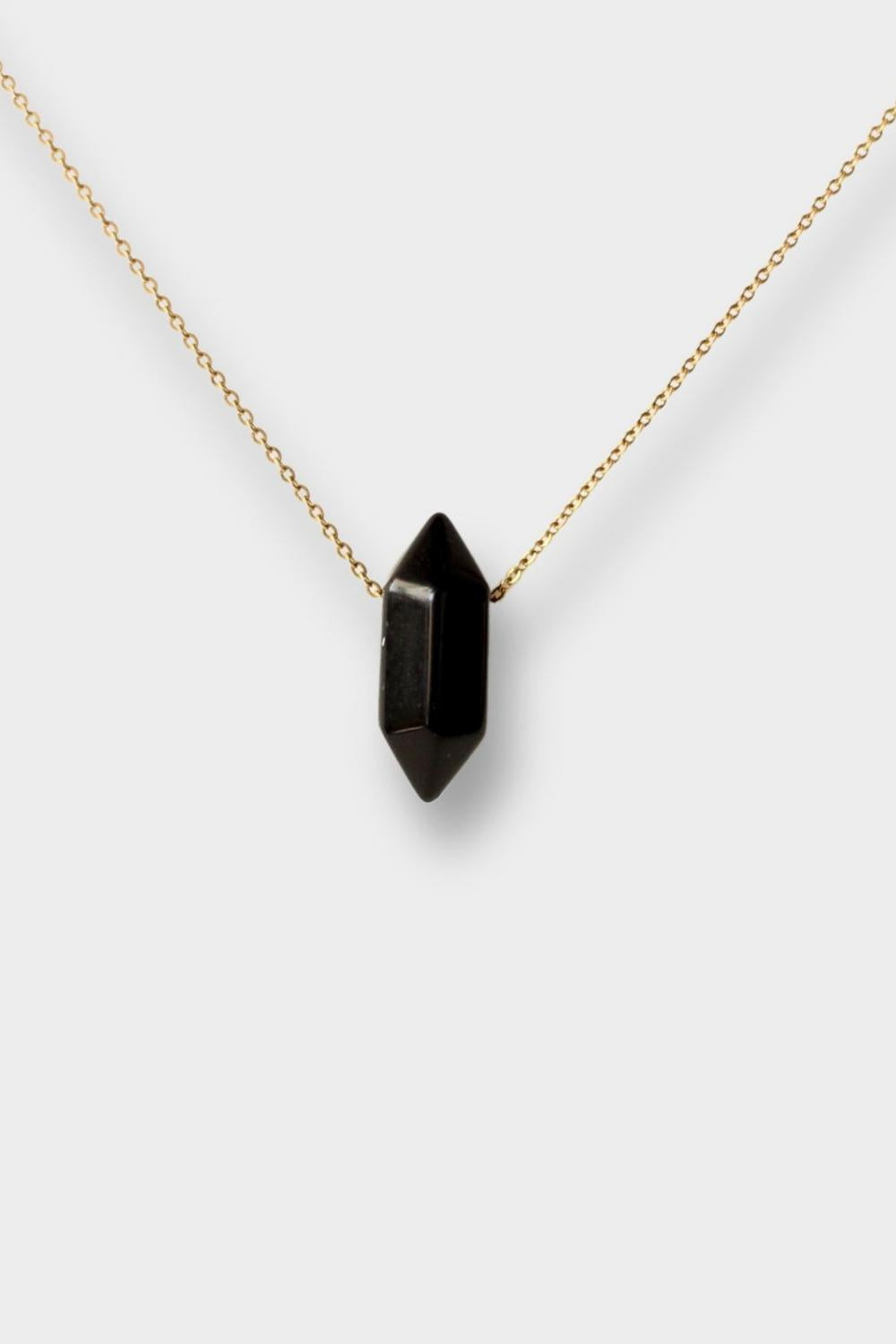 Black obsidian crystal necklace. The necklace features a pointed black obsidian crystal pendant attached to a gold chain, creating a stunning and eye-catching piece of jewelry.