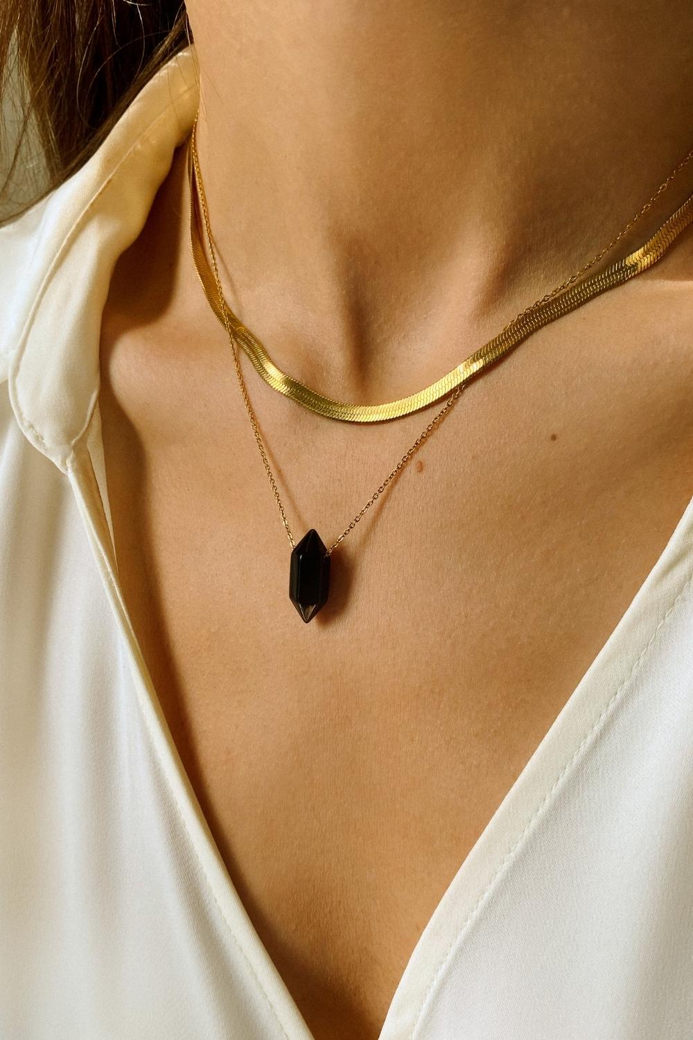 Black obsidian crystal necklace. The first necklace features a pointed black obsidian crystal pendant, while the second necklace features a delicate gold snake chain. Together, the necklaces create a stunning layered look that adds sophistication and elegance to any outfit.