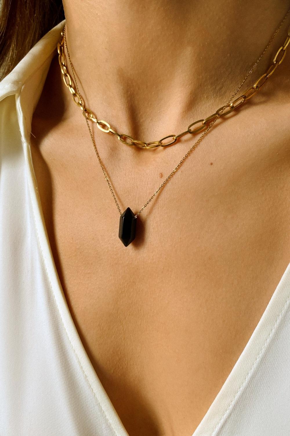 Black obsidian crystal necklace. The first necklace features a pointed black obsidian crystal pendant, while the second necklace features a delicate gold paper clip chain. Together, the necklaces create a stunning layered look that adds sophistication and elegance to any outfit.