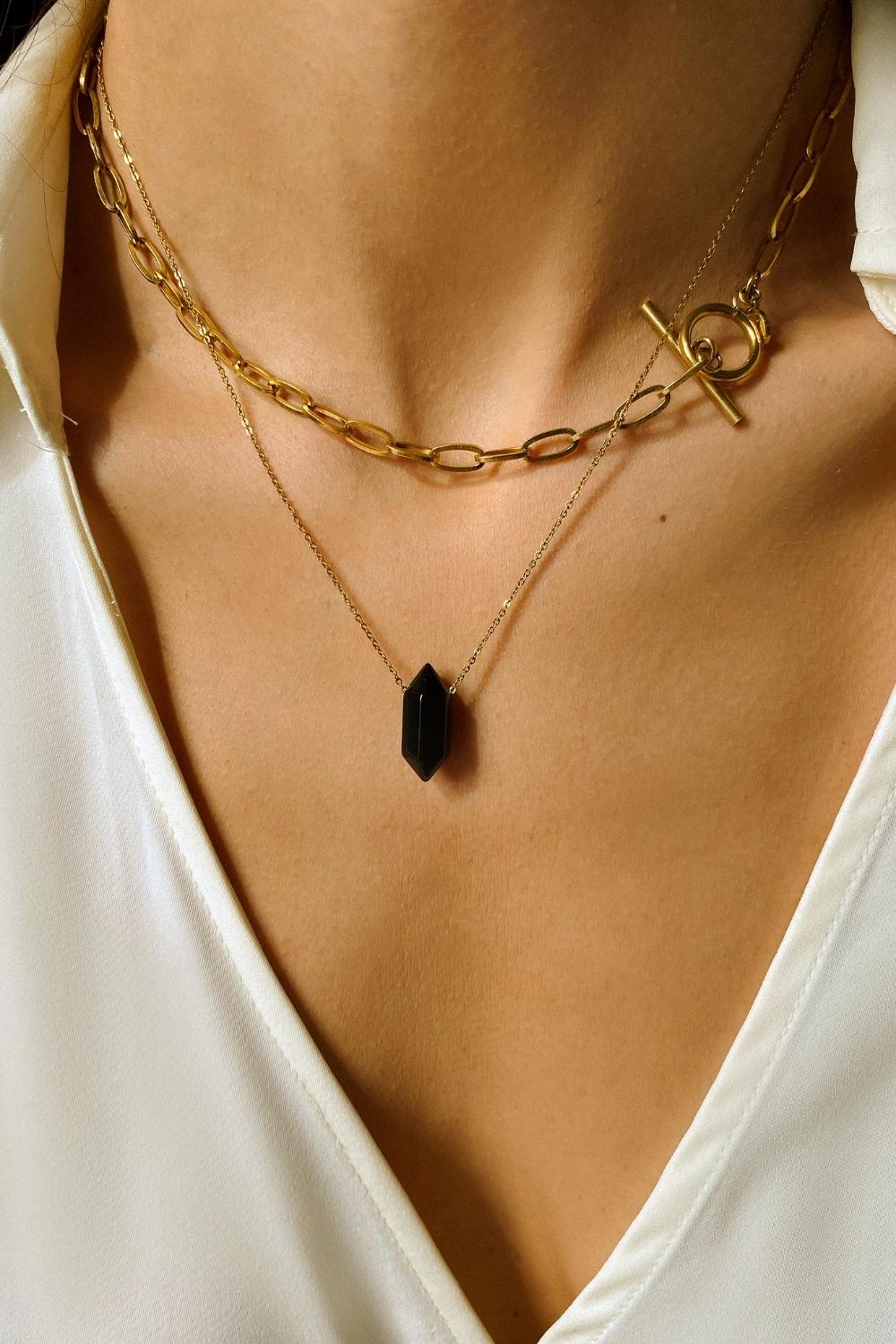 Black obsidian crystal necklace. The first necklace features a pointed black obsidian crystal pendant, while the second necklace features a delicate gold paper clip chain. Together, the necklaces create a stunning layered look that adds sophistication and elegance to any outfit.
