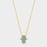 A blue Hamsa hand charm necklace in 18k gold plated silver. The necklace features a delicate chain with a beautifully designed Hamsa hand charm pendant. The Hamsa hand symbol is believed to bring protection, good luck, and ward off evil. The necklace is designed to be worn comfortably and can be adjusted to fit different neck sizes.