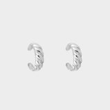 a croissant ear cuff in sterling silver. The ear cuff features a unique croissant-shaped design that wraps around the earlobe. It is made of high-quality silver with a polished finish, giving it a luxurious and elegant look. The cuff is designed to be worn without the need for a piercing, making it a trendy and versatile accessory.