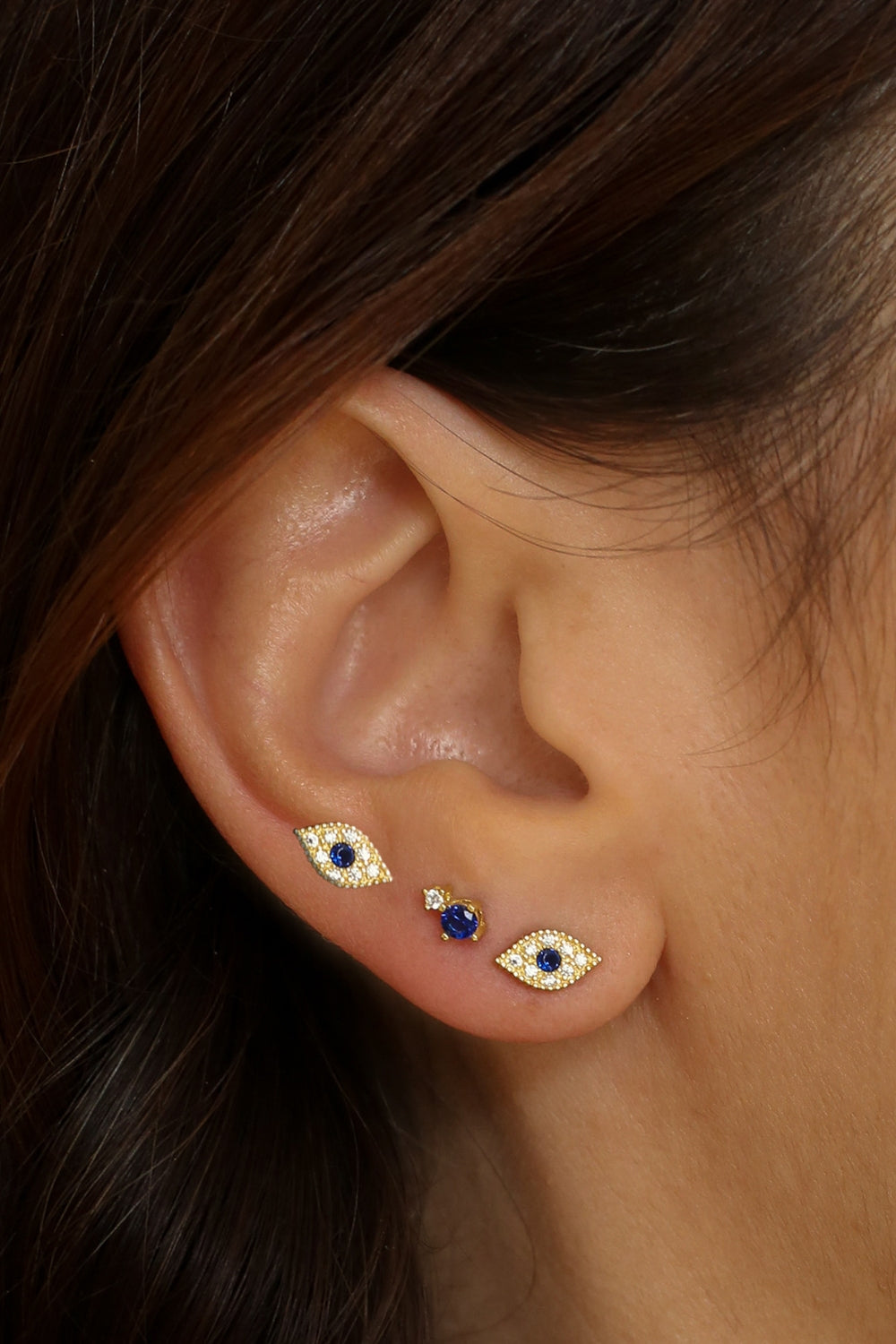 Evil eye stud earrings in 18k gold plated. The earrings feature a traditional evil eye design with a vibrant blue center. The evil eye symbol is believed to provide protection against negative energy and bring good luck. The studs are made of high-quality gold plated material with a polished finish, giving them a luxurious and elegant look.