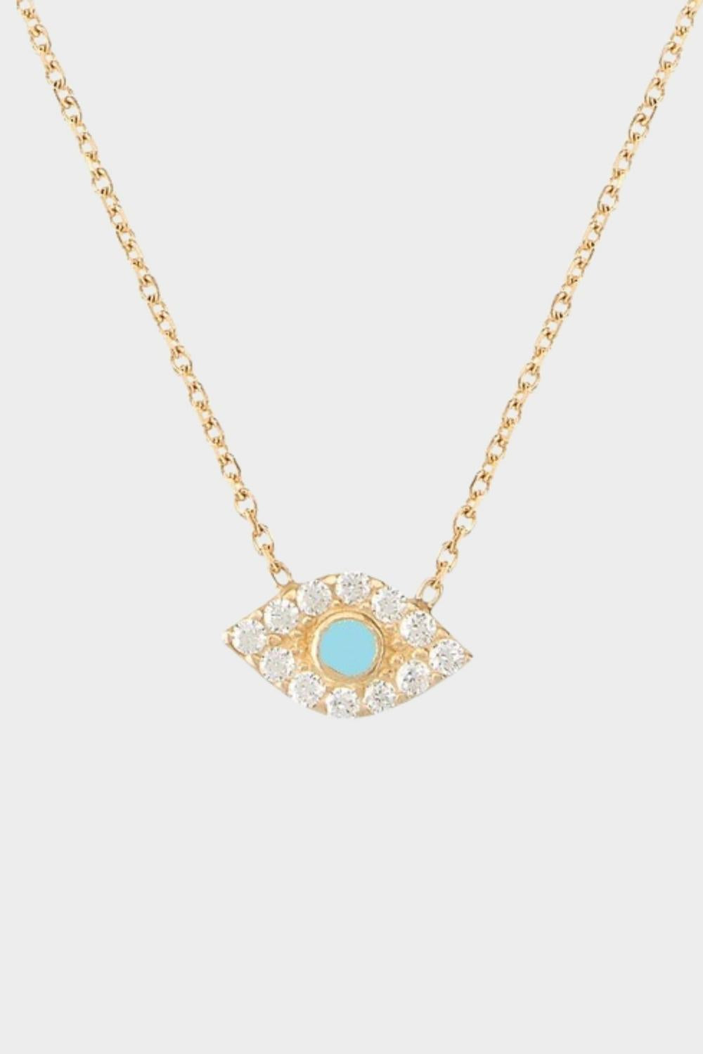 An evil eye charm necklace in 18k gold plated silver. The necklace features a delicate gold chain with an intricately designed evil eye charm pendant. The evil eye symbol is believed to provide protection against negative energies or ill-will, making this necklace both stylish and meaningful