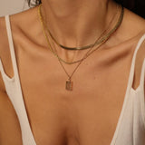A layered set of herringbone flat chains in 18k gold plated. The set includes three gold chains with a distinct herringbone pattern, all crafted in a luxurious gold color. The chains are layered together, creating a stylish and modern look. The herringbone pattern adds a unique texture and visual interest to the chains, while the gold color adds a touch of glamour