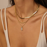 A layered set of herringbone flat chains in 18k gold plated. The set includes three gold chains with a distinct herringbone pattern, all crafted in a luxurious gold color. The chains are layered together, creating a stylish and modern look. The herringbone pattern adds a unique texture and visual interest to the chains, while the gold color adds a touch of glamour