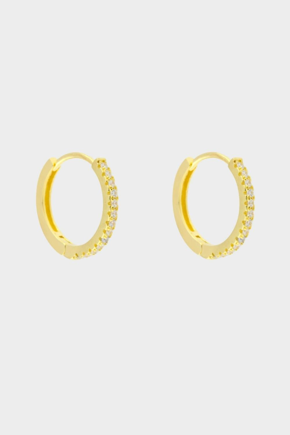 Diamond huggie hoops in 18k gold plated silver. The earrings feature a classic huggie-style design adorned with sparkling diamonds. The diamonds are meticulously set along the front of the hoops, adding a touch of luxury and glamour. The hoops are made of high-quality gold plated silver and have a polished finish.