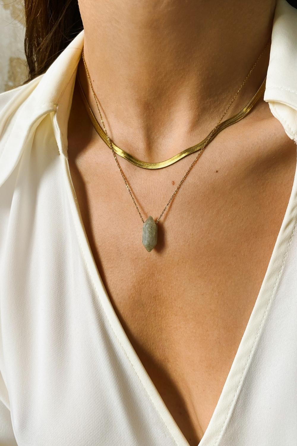 Labradorite crystal necklace. The first necklace features a pointed labradorite crystal pendant, while the second necklace features a delicate gold snake chain. Together, the necklaces create a stunning layered look that adds sophistication and elegance to any outfit.