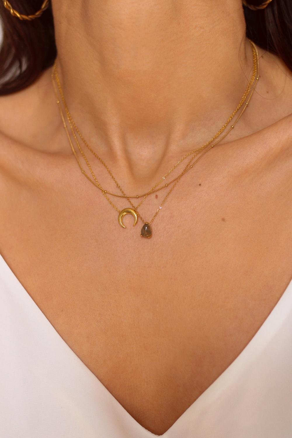 A layered necklaces set that includes a labradorite stone pendant necklace, moon necklace and a satellite chain in 18k gold plated silver. The set features a stunning labradorite stone pendant necklace, crafted with a beautiful gold bezel and suspended from a delicate gold chain. Along with the labradorite stone pendant necklace, the set also includes a stylish satellite chain, that adds a trendy and modern touch to the jewelry collection.