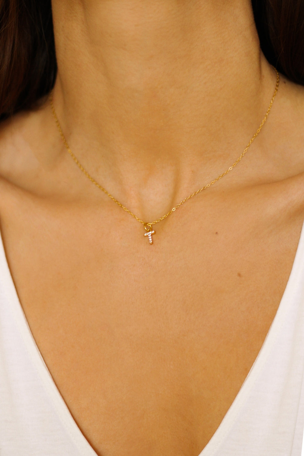 An initial pendant necklace in 18k gold plated silver. The necklace features a delicate gold chain, with a pendant in the shape of a single letter T from the alphabet. The pendant is intricately designed, showcasing the initial with a stylish and elegant font. Perfect for gifting or adding a personal touch to any outfit.