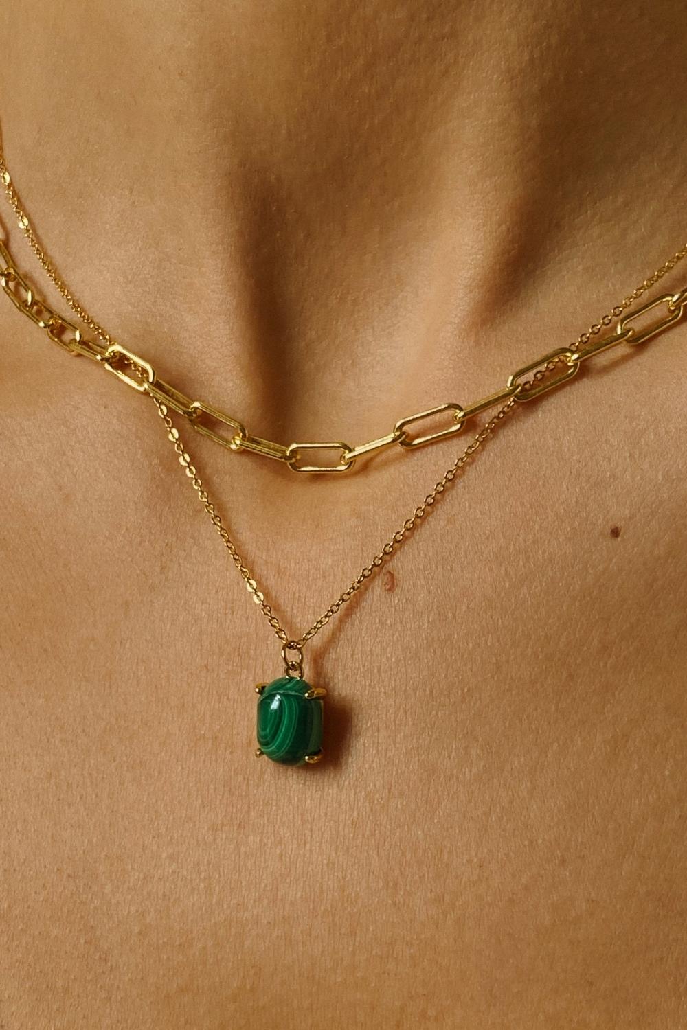 A malachite stone pendant necklace in 18k gold plated silver. The necklace features a stunning malachite stone pendant that is beautifully crafted and set in a gold bezel. The malachite stone exhibits vibrant shades of green with unique patterns, creating a captivating and natural look. The pendant is suspended from a delicate gold chain, adding elegance and sophistication to the necklace