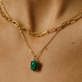 A malachite stone pendant necklace in 18k gold plated silver. The necklace features a stunning malachite stone pendant that is beautifully crafted and set in a gold bezel. The malachite stone exhibits vibrant shades of green with unique patterns, creating a captivating and natural look. The pendant is suspended from a delicate gold chain, adding elegance and sophistication to the necklace