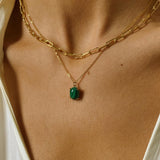 A layered necklaces set that includes a malachite stone pendant necklace and a paper clip chain in 18k gold plated silver.The set features a stunning malachite stone pendant necklace, crafted with a beautiful gold bezel and suspended from a delicate gold chain. Along with the malachite stone pendant necklace, the set also includes a stylish paper clip chain, that adds a trendy and modern touch to the jewelry collection.