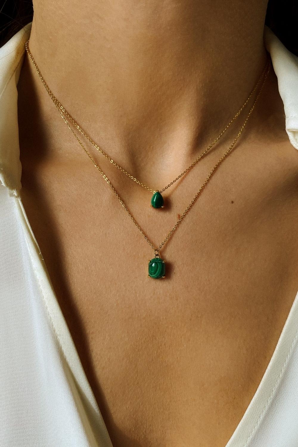 A malachite stone pendant necklace in 18k gold plated silver. The necklace features a stunning malachite stone pendant that is beautifully crafted and set in a gold bezel. The malachite stone exhibits vibrant shades of green with unique patterns, creating a captivating and natural look. The pendant is suspended from a delicate gold chain, adding elegance and sophistication to the necklace