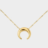 A moon necklace in 18k gold plated silver. The necklace features a delicate gold chain with a pendant in the shape of a crescent moon. The necklace is perfect for those who love celestial-inspired jewelry, and makes for an elegant and stylish accessory that can be worn on any occasion.
