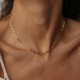 18k gold plated over sterling silver paper clip chain choker. The choker is composed of interlocking paper clip-shaped links, with each link carefully plated in 18k gold for a luxurious and radiant shine. The paper clip chain design gives the necklace a trendy and contemporary look. The choker is designed to sit comfortably around the neck, creating a stylish and fashionable accessory that can be worn alone or layered with other necklaces