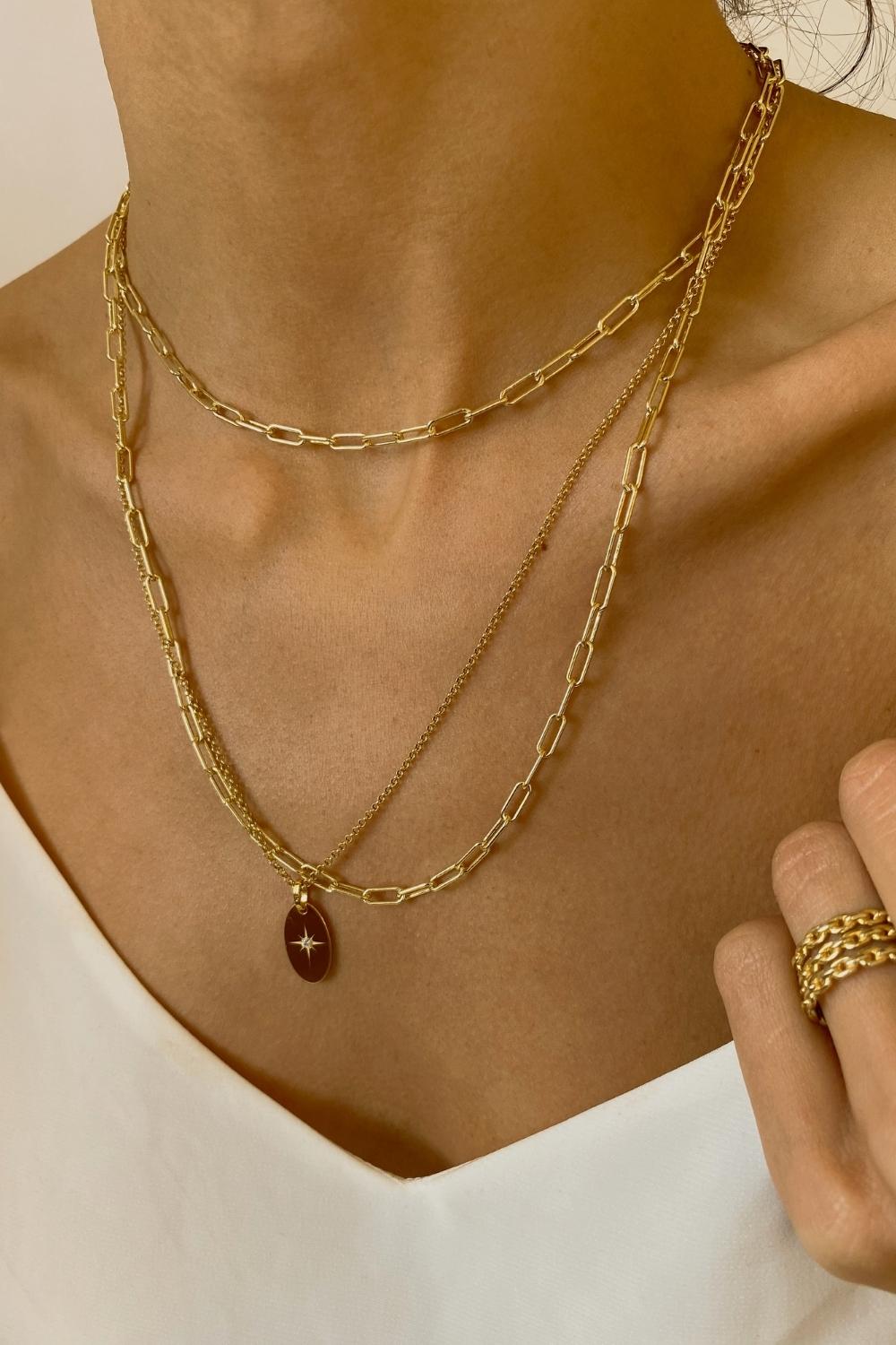 18k gold plated over sterling silver paper clip chain choker. The choker is composed of interlocking paper clip-shaped links, with each link carefully plated in 18k gold for a luxurious and radiant shine. The paper clip chain design gives the necklace a trendy and contemporary look. The choker is designed to sit comfortably around the neck, creating a stylish and fashionable accessory that can be worn alone or layered with other necklaces