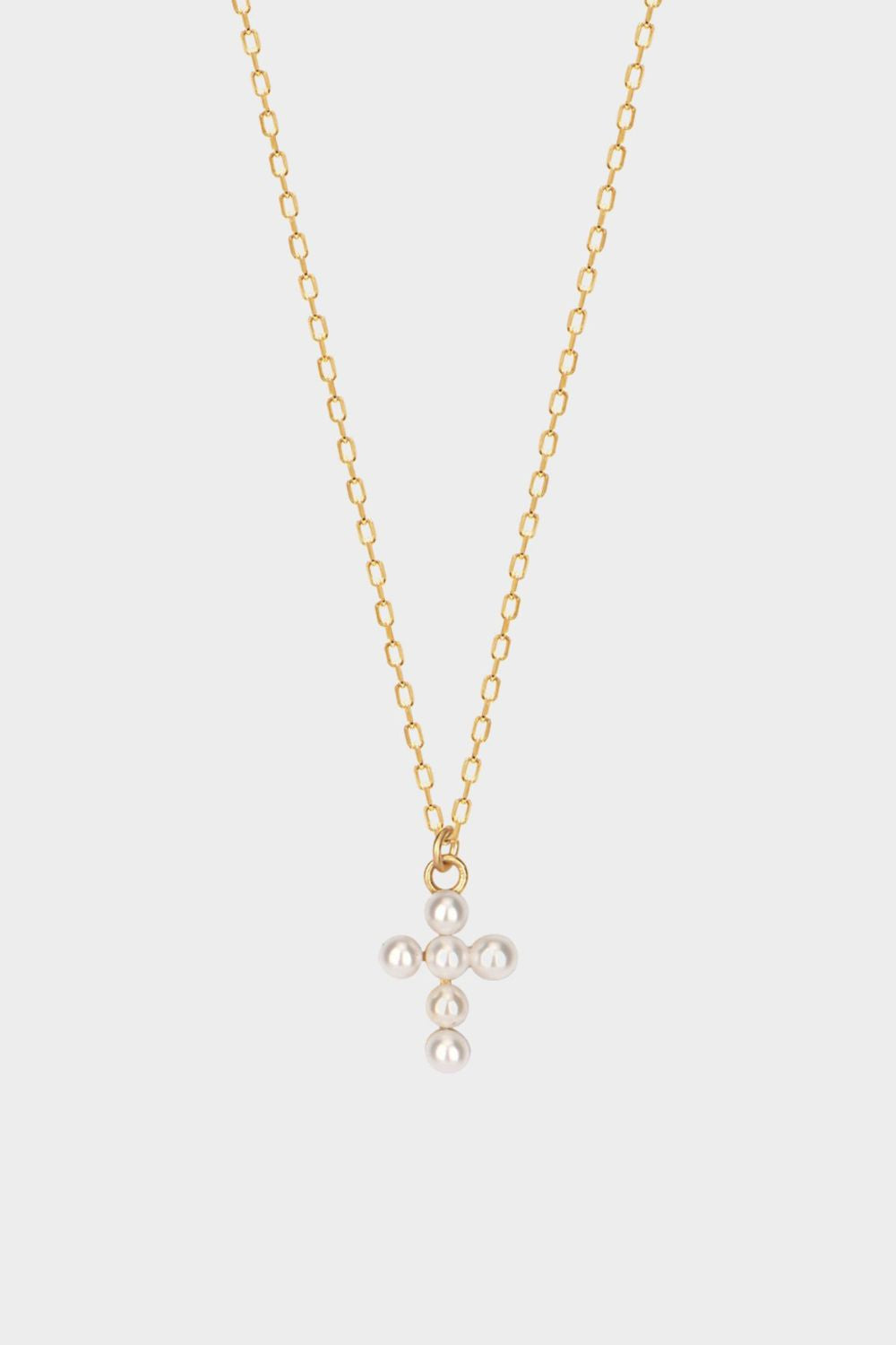 Pearl cross pendant necklace in 18k gold plated silver. The necklace features a delicate gold-plated silver chain with a pendant in the shape of a cross. The cross pendant is adorned with lustrous white pearls, adding a touch of elegance and femininity to the design. The necklace is crafted with meticulous attention to detail, creating a timeless and religious-inspired piece of jewelry. It can be worn as a symbolic accessory or as a fashionable statement piece.