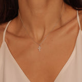 Pearl cross pendant necklace in 925 sterling silver. The necklace features a delicate silver chain with a pendant in the shape of a cross. The cross pendant is adorned with lustrous white pearls, adding a touch of elegance and femininity to the design. The necklace is crafted with meticulous attention to detail, creating a timeless and religious-inspired piece of jewelry. It can be worn as a symbolic accessory or as a fashionable statement piece.