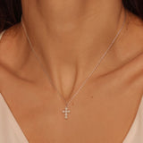 Pearl cross pendant necklace in 925 sterling silver. The necklace features a delicate silver chain with a pendant in the shape of a cross. The cross pendant is adorned with lustrous white pearls, adding a touch of elegance and femininity to the design. The necklace is crafted with meticulous attention to detail, creating a timeless and religious-inspired piece of jewelry. It can be worn as a symbolic accessory or as a fashionable statement piece.