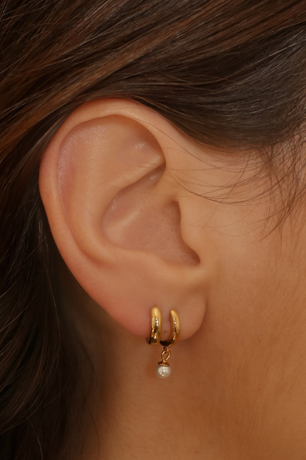 plain huggie hoops in 18k gold plated silver. The earrings feature a classic huggie-style design with a simple and sleek look. The hoops are made of high-quality gold plated silver and have a polished finish
