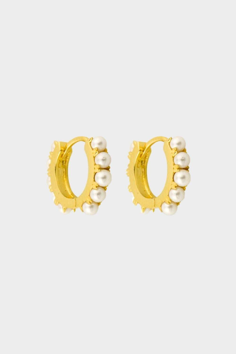 Beaded pearl huggies in 18k gold plated silver. The earrings feature a classic hoop design adorned with delicate beads and lustrous pearls. The gold plated silver adds a touch of elegance and sophistication to the design. The pearls are beautifully strung along the hoops, adding a timeless and glamorous element.