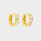 Beaded pearl huggies in 18k gold plated silver. The earrings feature a classic hoop design adorned with delicate beads and lustrous pearls. The gold plated silver adds a touch of elegance and sophistication to the design. The pearls are beautifully strung along the hoops, adding a timeless and glamorous element.
