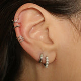 Beaded pearl huggies in sterling silver. The earrings feature a classic hoop design adorned with delicate beads and lustrous pearls. The silver adds a touch of elegance and sophistication to the design. The pearls are beautifully strung along the hoops, adding a timeless and glamorous element.