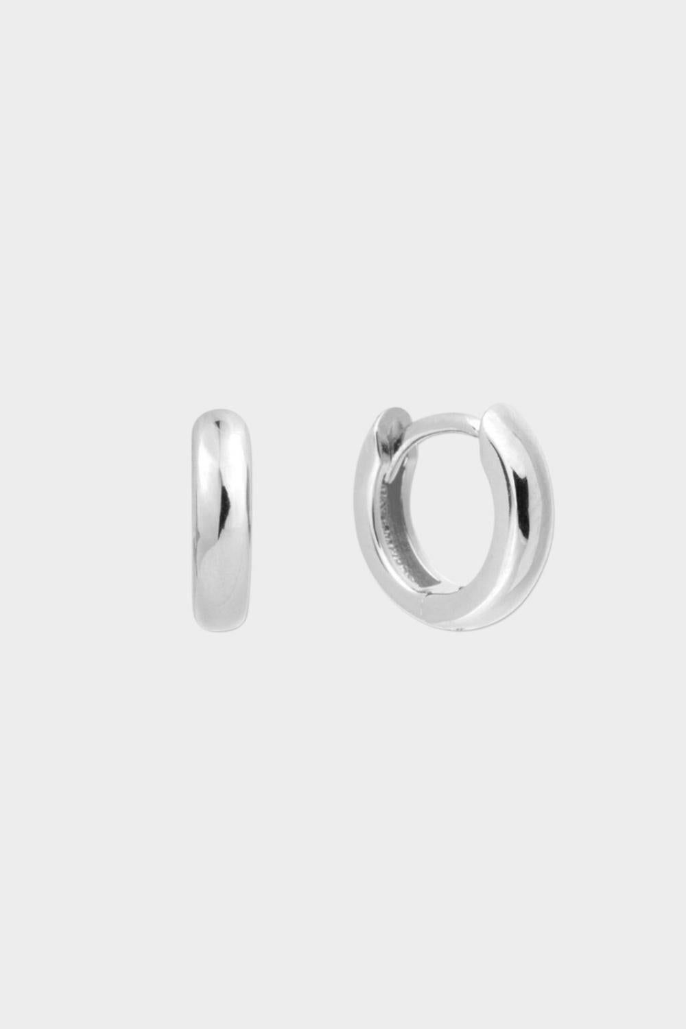 Plain huggie hoops in sterling silver. The earrings feature a classic huggie-style design with a simple and sleek look. The hoops are made of high-quality silver and have a polished finish.