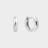 Plain huggie hoops in sterling silver. The earrings feature a classic huggie-style design with a simple and sleek look. The hoops are made of high-quality silver and have a polished finish.