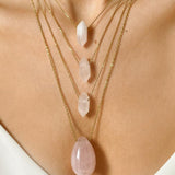 Rose Quartz crystal necklace. The first necklace features a pointed rose quartz crystal pendant, while the second necklace features a delicate gold paper clip chain. Together, the necklaces create a stunning layered look that adds sophistication and elegance to any outfit.