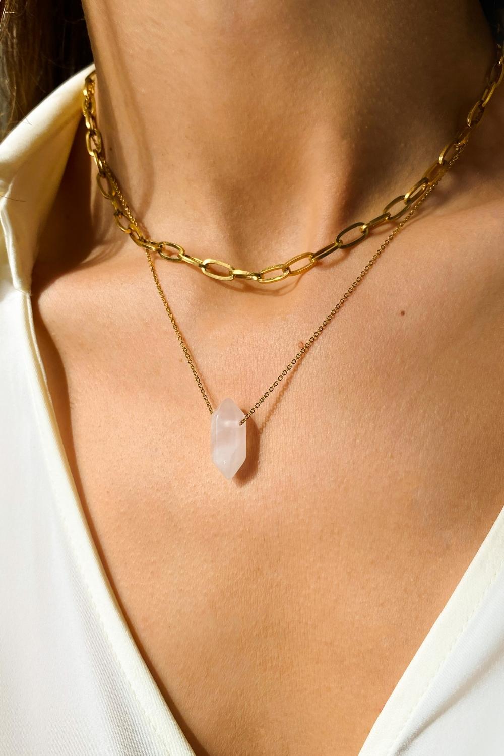 Rose Quartz crystal necklace. The first necklace features a pointed rose quartz crystal pendant, while the second necklace features a delicate gold paper clip chain. Together, the necklaces create a stunning layered look that adds sophistication and elegance to any outfit.