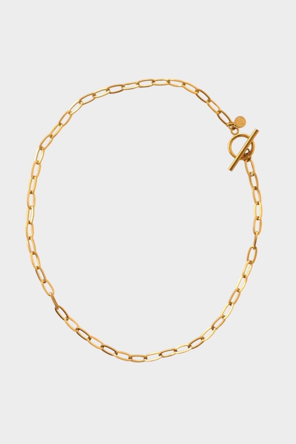 18k gold plated toggle choker necklace. The necklace features a sleek and minimalistic design, with a single chain crafted from high-quality metal and plated with 18k gold for a luxurious finish. The centerpiece of the necklace is a toggle closure, consisting of a small, decorative gold ring and a bar that fits through it to secure the necklace. This chic and elegant accessory adds a touch of sophistication to any outfit
