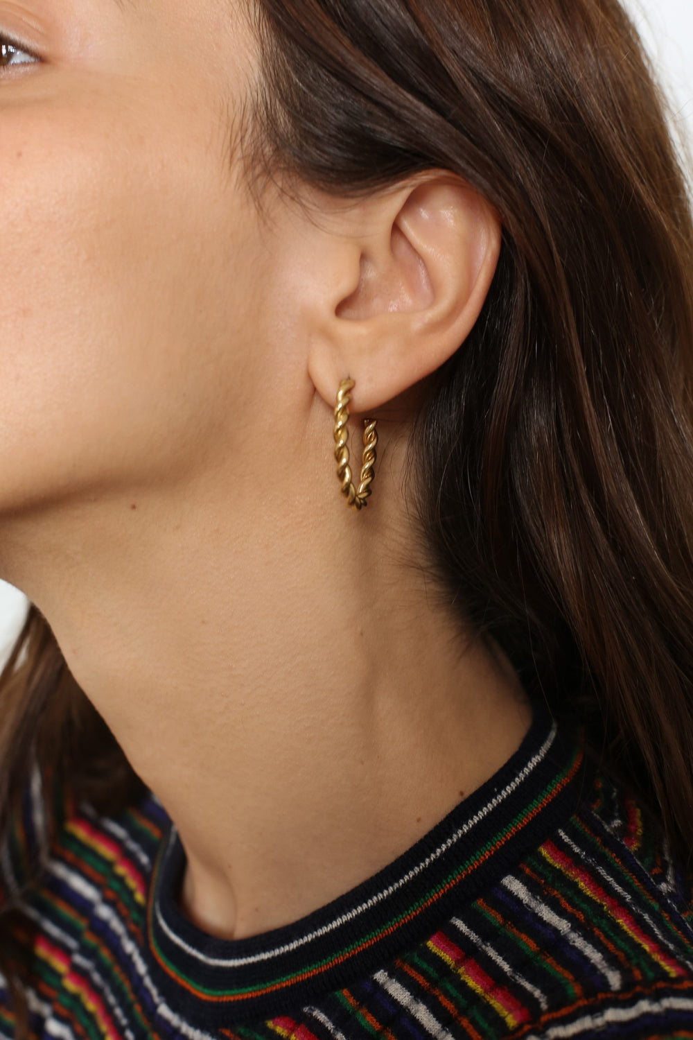 Twisted hoops in 18k gold plated. The earrings feature a unique and eye-catching twisted design. The gold plated material adds a touch of luxury and elegance. These hoops have a polished finish that enhances their shine.