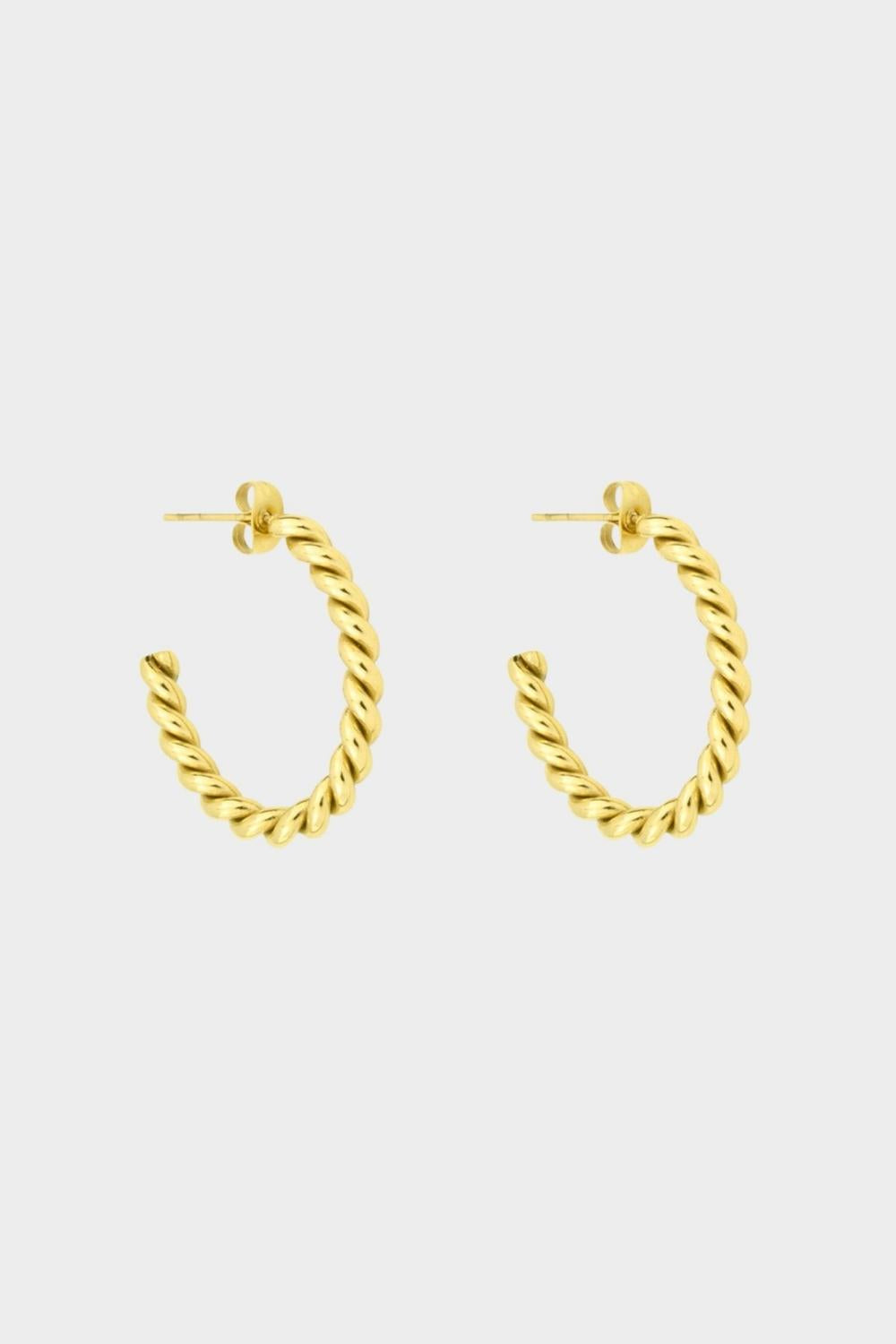Twisted hoops in 18k gold plated. The earrings feature a unique and eye-catching twisted design. The gold plated material adds a touch of luxury and elegance. These hoops have a polished finish that enhances their shine.
