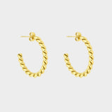 Twisted hoops in 18k gold plated. The earrings feature a unique and eye-catching twisted design. The gold plated material adds a touch of luxury and elegance. These hoops have a polished finish that enhances their shine.
