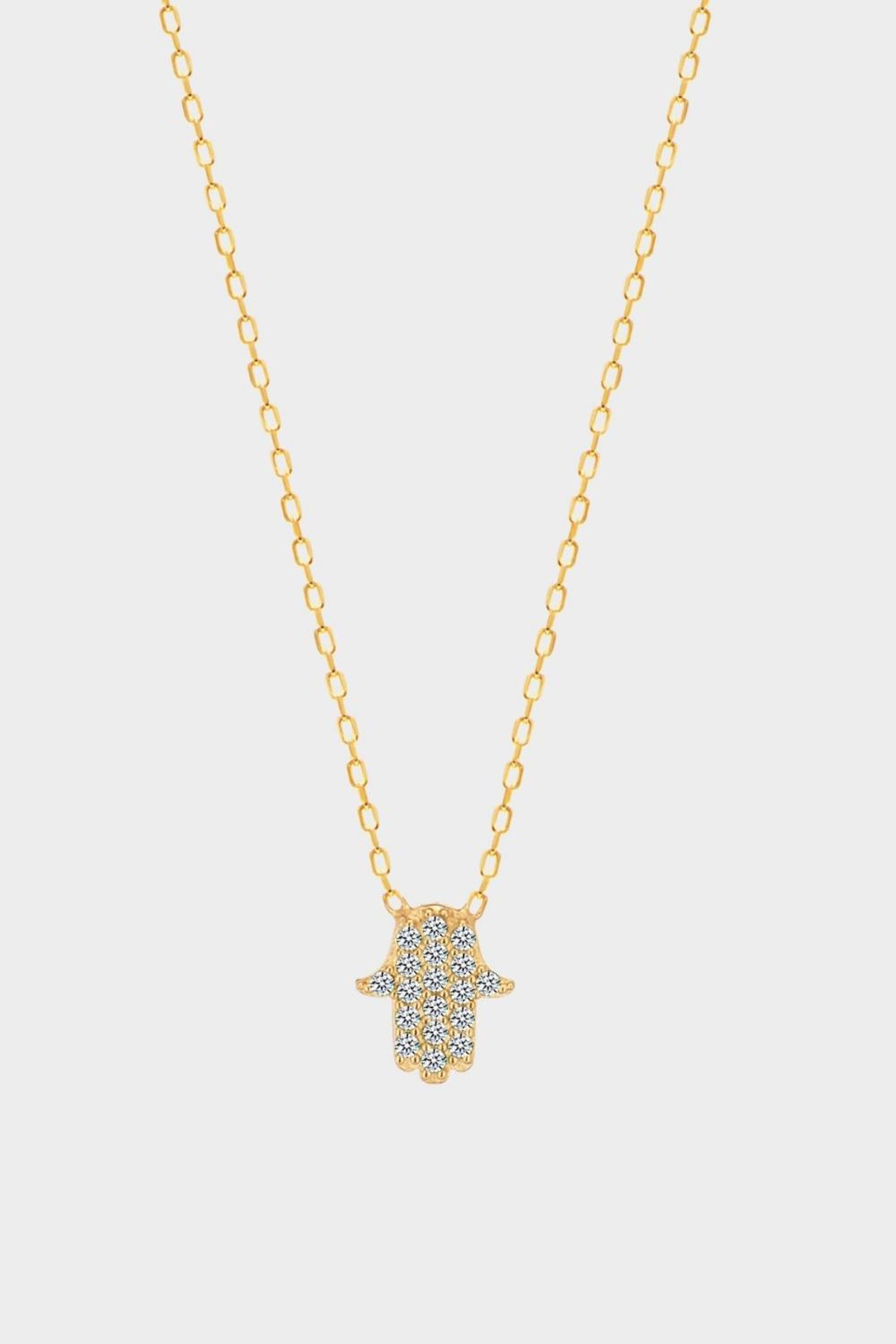 A White Hamsa hand charm necklace in 18k gold plated silver. The necklace features a delicate chain with a beautifully designed Hamsa hand charm pendant. The Hamsa hand symbol is believed to bring protection, good luck, and ward off evil. The necklace is designed to be worn comfortably and can be adjusted to fit different neck sizes.