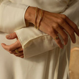 a 18k gold vermeil cuff bracelet with a round shape. The bracelet is made entirely of silver, with a smooth and polished finish. This versatile 18k gold vermeil cuff bracelet adds a touch of elegance and sophistication to any wrist.