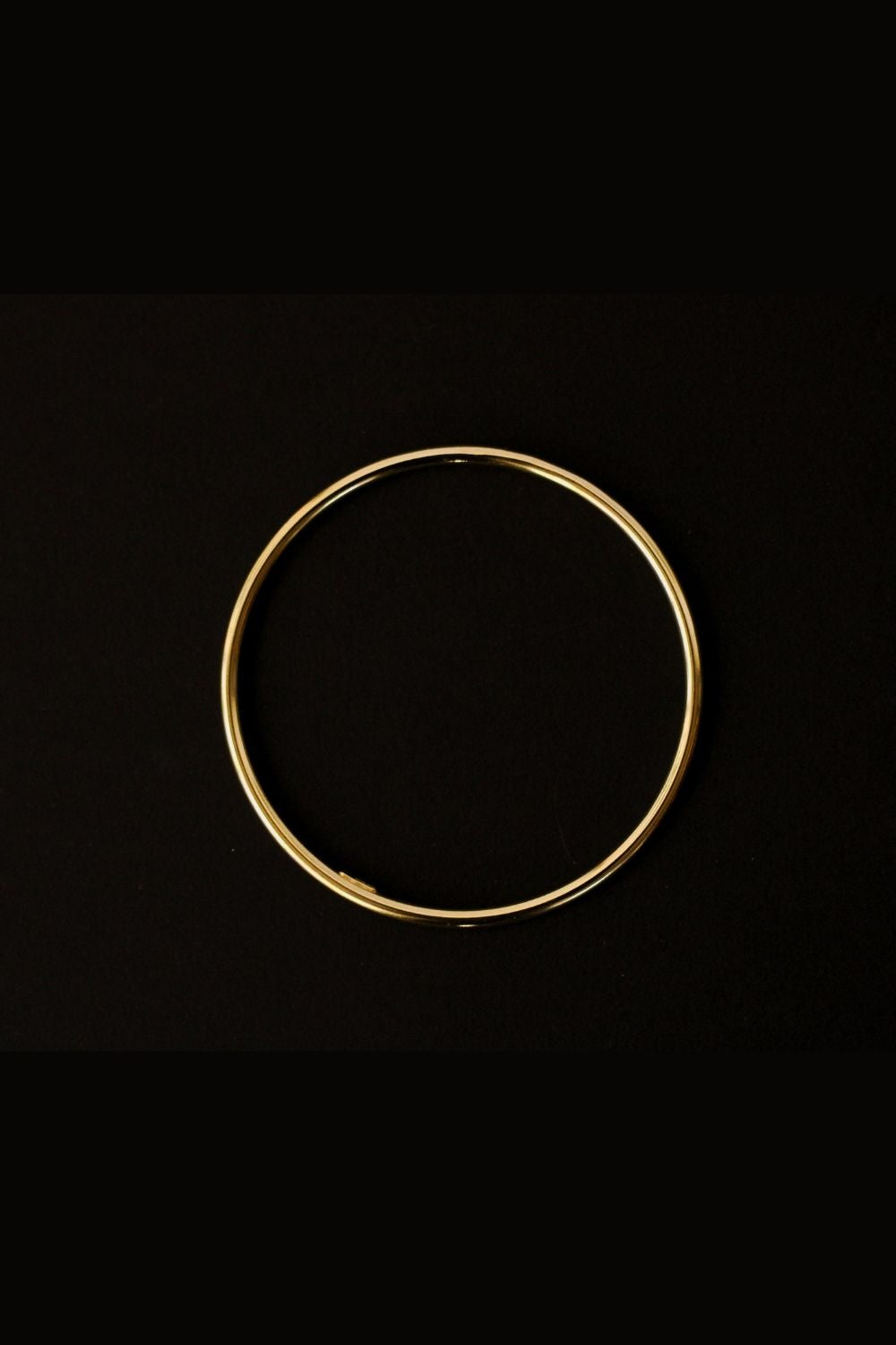 a 18k gold vermeil cuff bracelet with a round shape. The bracelet is made entirely of silver, with a smooth and polished finish. This versatile 18k gold vermeil cuff bracelet adds a touch of elegance and sophistication to any wrist.