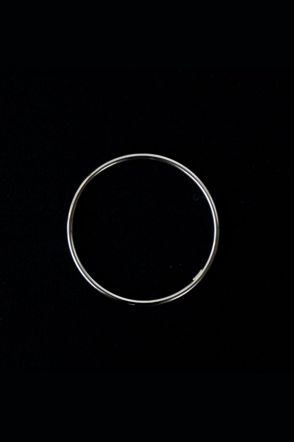 a silver cuff bracelet with a round shape. The bracelet is made entirely of silver, with a smooth and polished finish. This versatile silver cuff bracelet adds a touch of elegance and sophistication to any wrist.