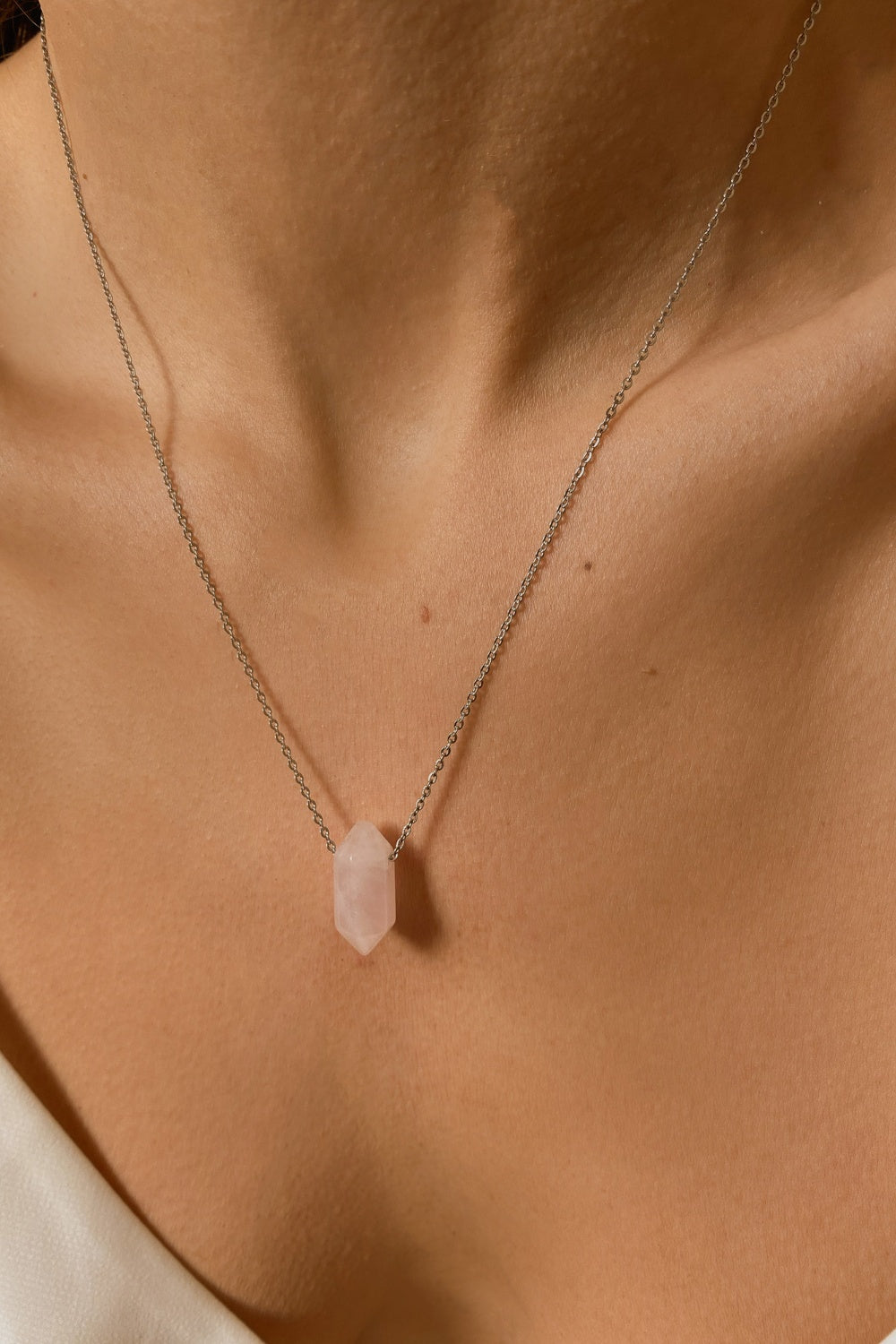 Rose Quartz crystal necklace. The first necklace features a pointed rose quartz crystal pendant, while the second necklace features a delicate gold snake chain. Together, the necklaces create a stunning layered look that adds sophistication and elegance to any outfit.