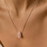 Rose Quartz crystal necklace. The first necklace features a pointed rose quartz crystal pendant, while the second necklace features a delicate gold snake chain. Together, the necklaces create a stunning layered look that adds sophistication and elegance to any outfit.