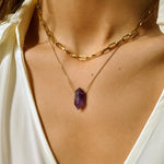 Natural Amethyst crystal necklace. The first necklace features a pointed amethyst crystal pendant, while the second necklace features a delicate gold paper clip chain. Together, the necklaces create a stunning layered look that adds sophistication and elegance to any outfit.