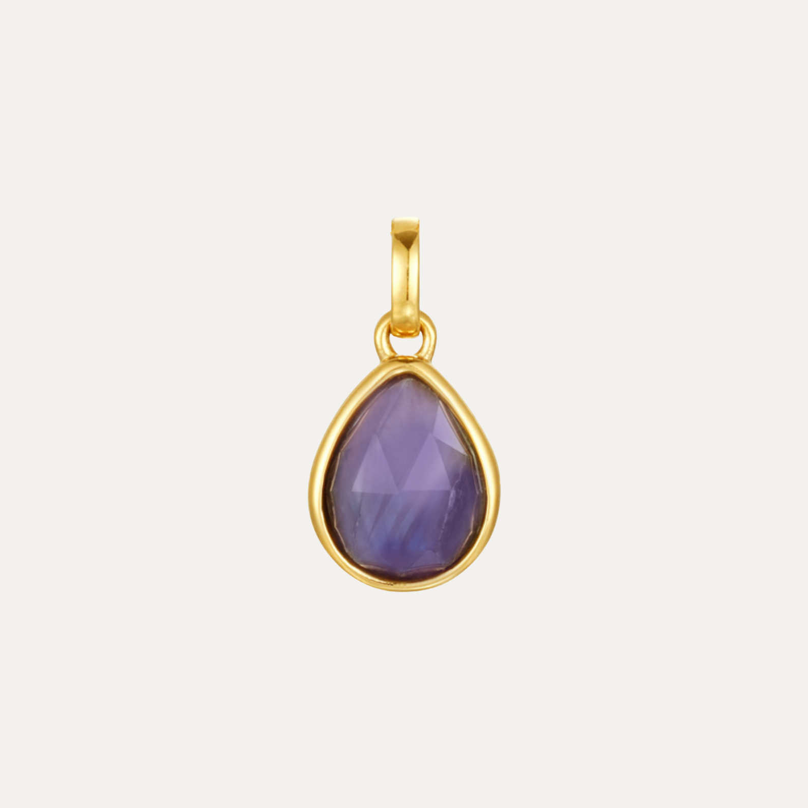 Gold pendant with a purple teardrop-shaped gemstone on a light gray background