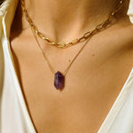 Natural Amethyst crystal necklace. The first necklace features a pointed amethyst crystal pendant, while the second necklace features a delicate gold paper clip chain. Together, the necklaces create a stunning layered look that adds sophistication and elegance to any outfit.